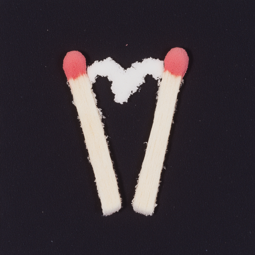 Two matchsticks in heart shape, flash photography, film.