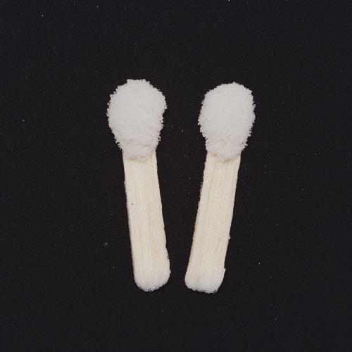 Two matchsticks making heart shape, flash photography, film.