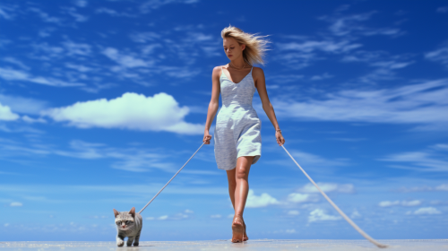 Woman walking cat on Bali beach