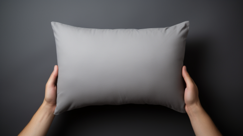 Close-up of hands holding a gray pillow