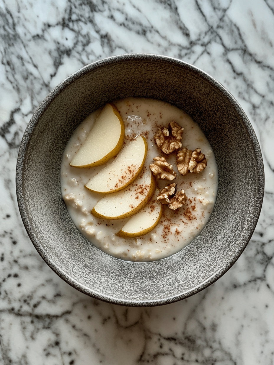 A cozy breakfast bowl with oatmeal, pear, and walnuts