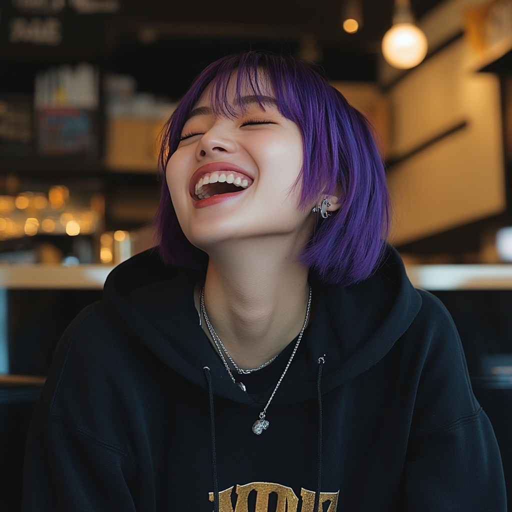 Laughing young Korean woman with purple bob, septum piercing.