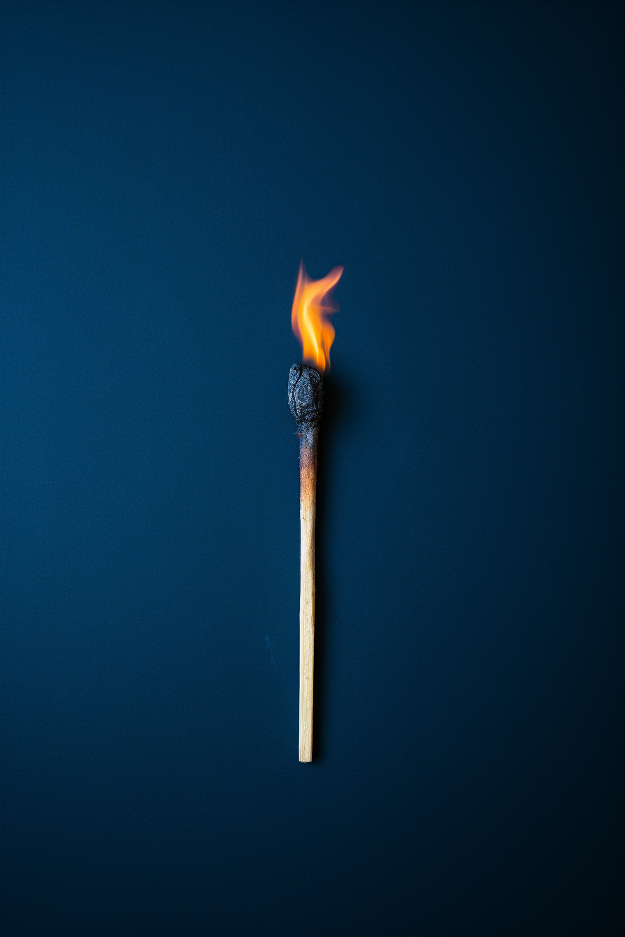 burned match on dark blue background