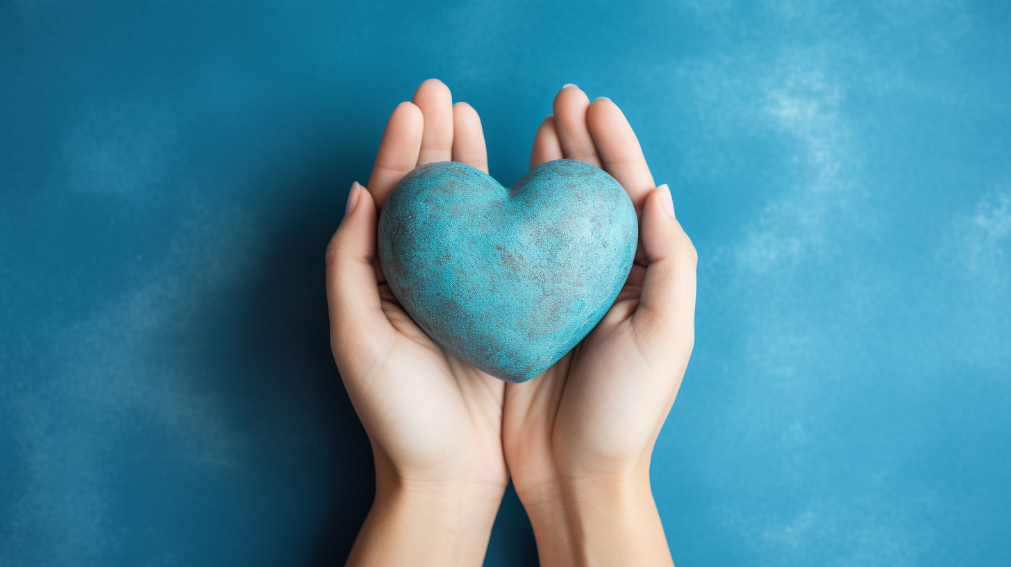 Hands holding heart on blue background